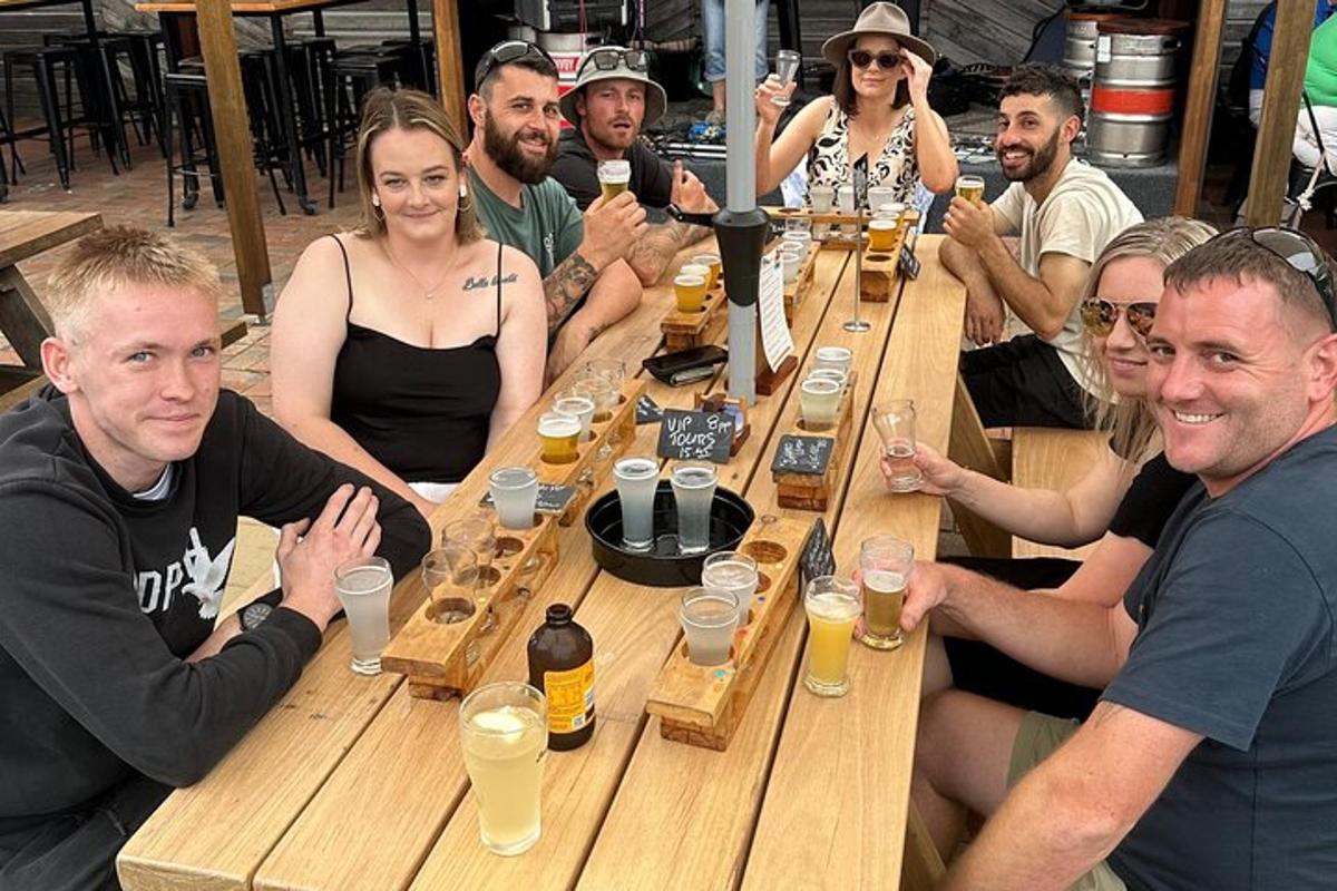 a group of people sitting around a table with beers
