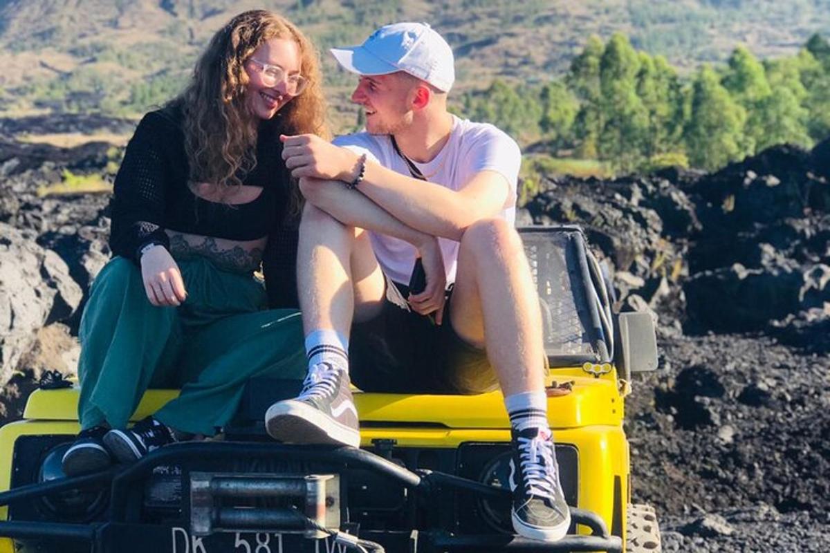 două persoane așezate pe acoperișul unui jeep