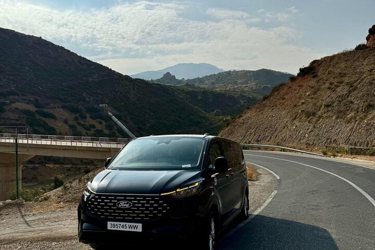 sebuah kereta hitam memandu di jalan raya di atas gunung