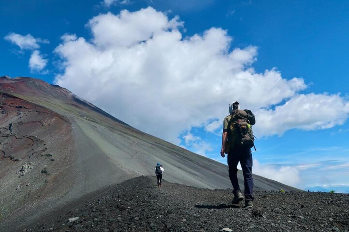 una persona con uno zaino che sale su una montagna
