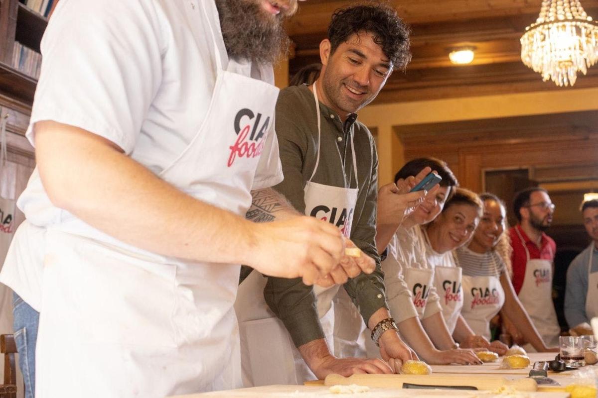 een man in een keuken die eten op een tafel snijdt