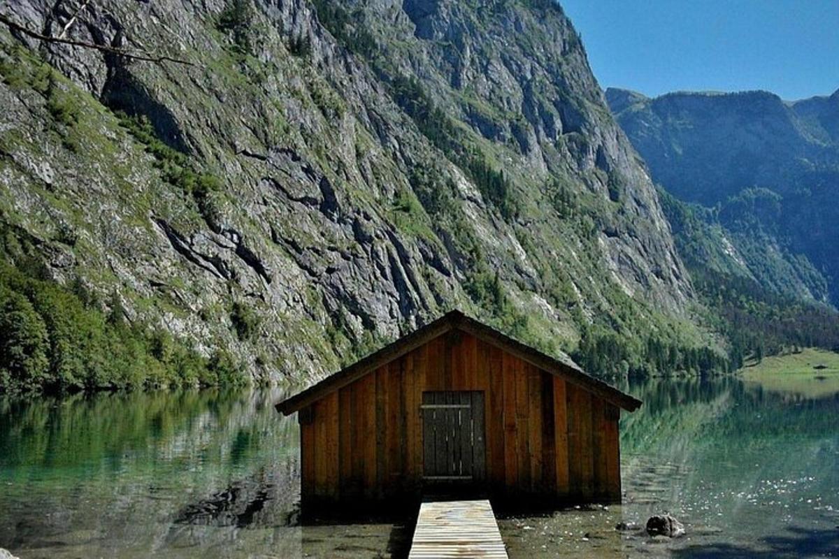 a small wooden cabin in the middle of a lake
