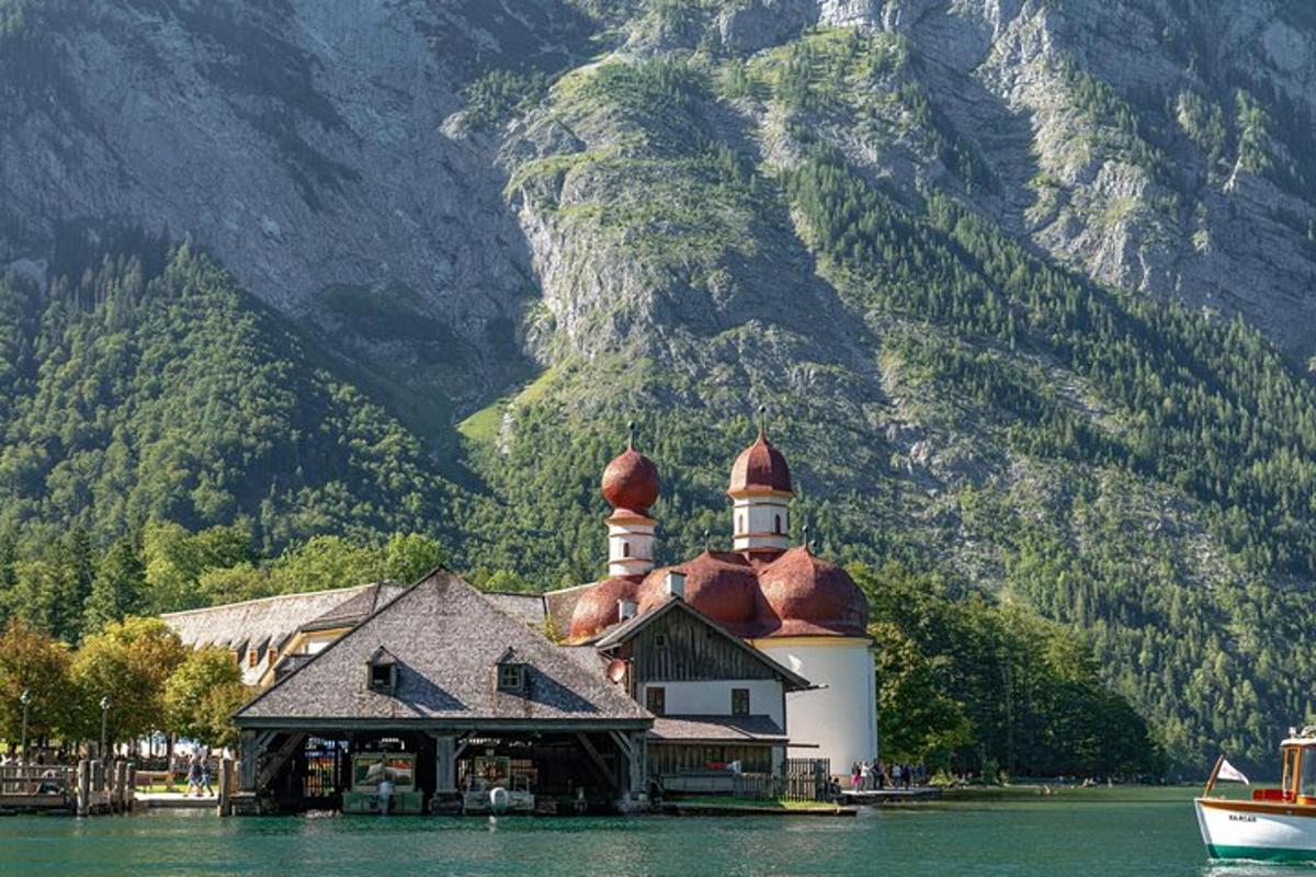 a building on the water with a mountain in the background