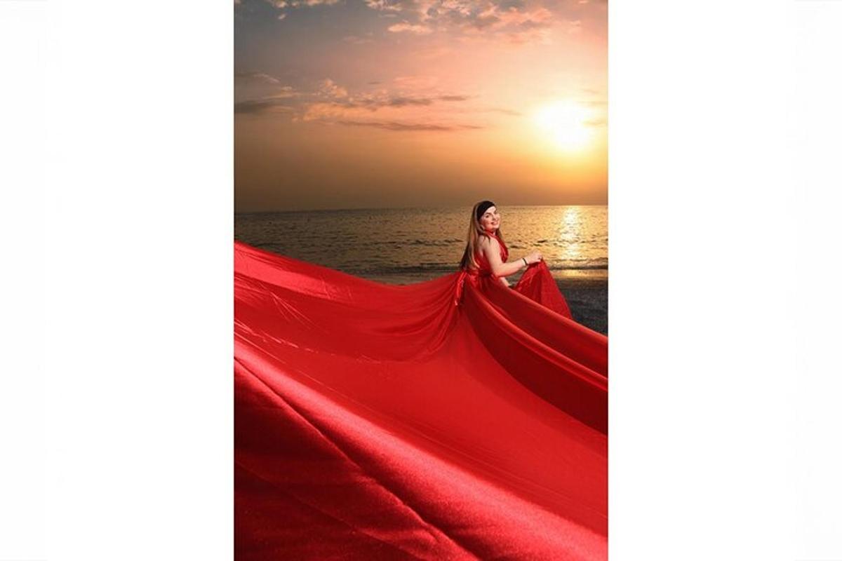 una donna in un vestito rosso sulla spiaggia