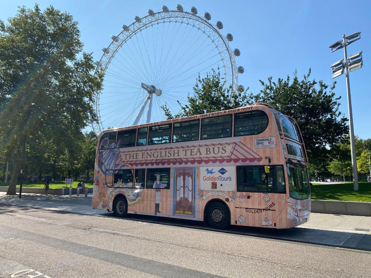 a double decker bus driving past a ferris wheel