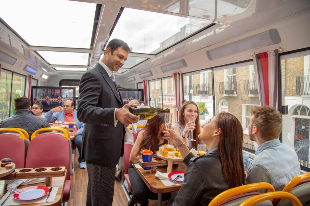 un uomo in giacca e cravatta sta servendo cibo su un treno
