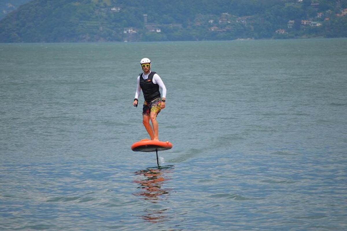 Muž stojí na paddleboardu ve vodě