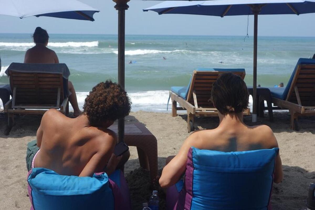 dua orang duduk di kerusi di pantai