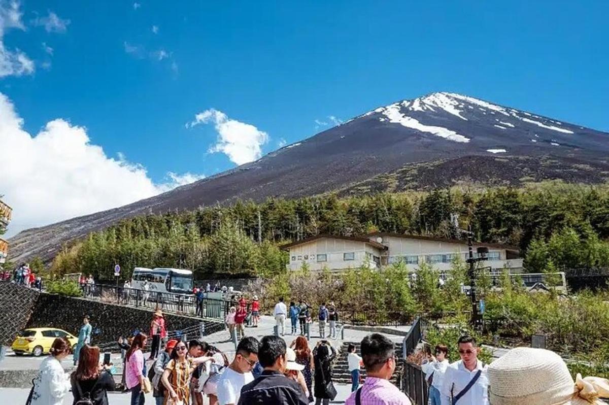 sekelompok orang berdiri di depan gunung