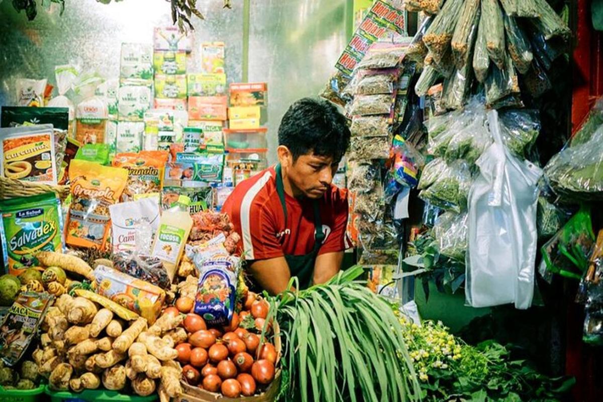 um homem em uma loja com uma pilha de vegetais