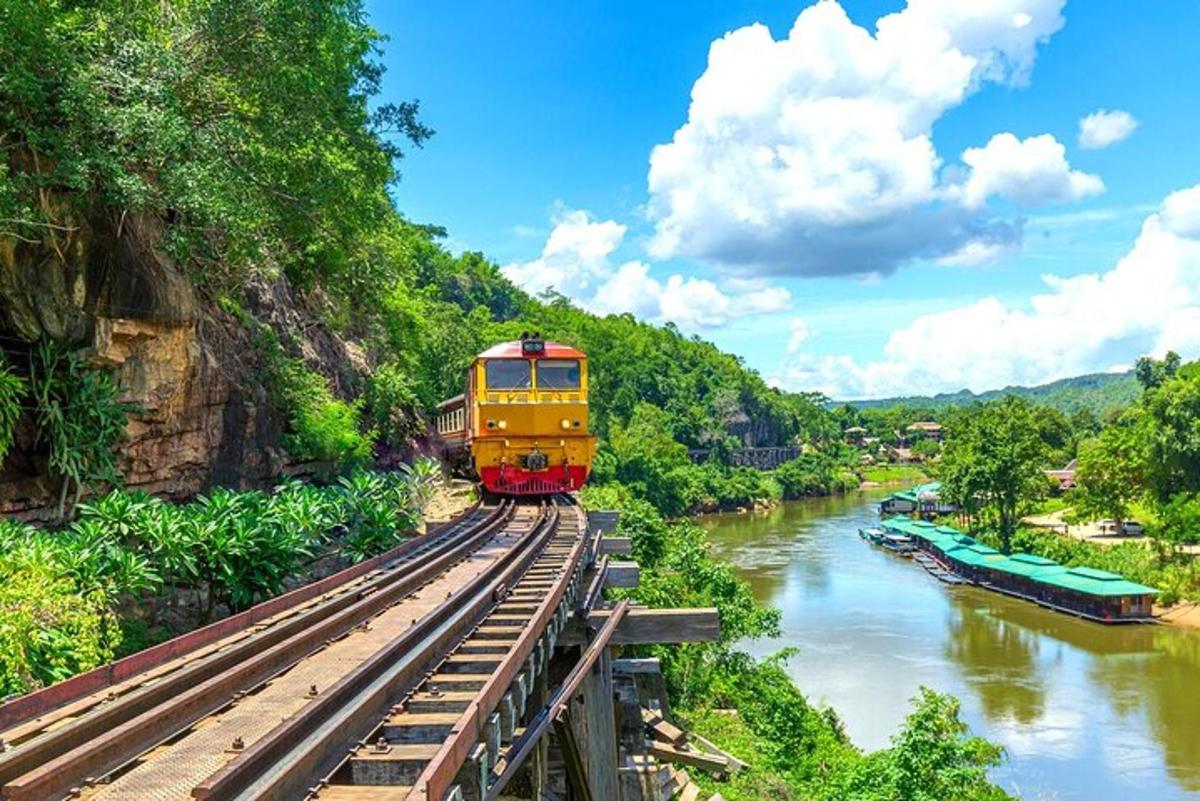 un tren groc en un pont sobre un riu