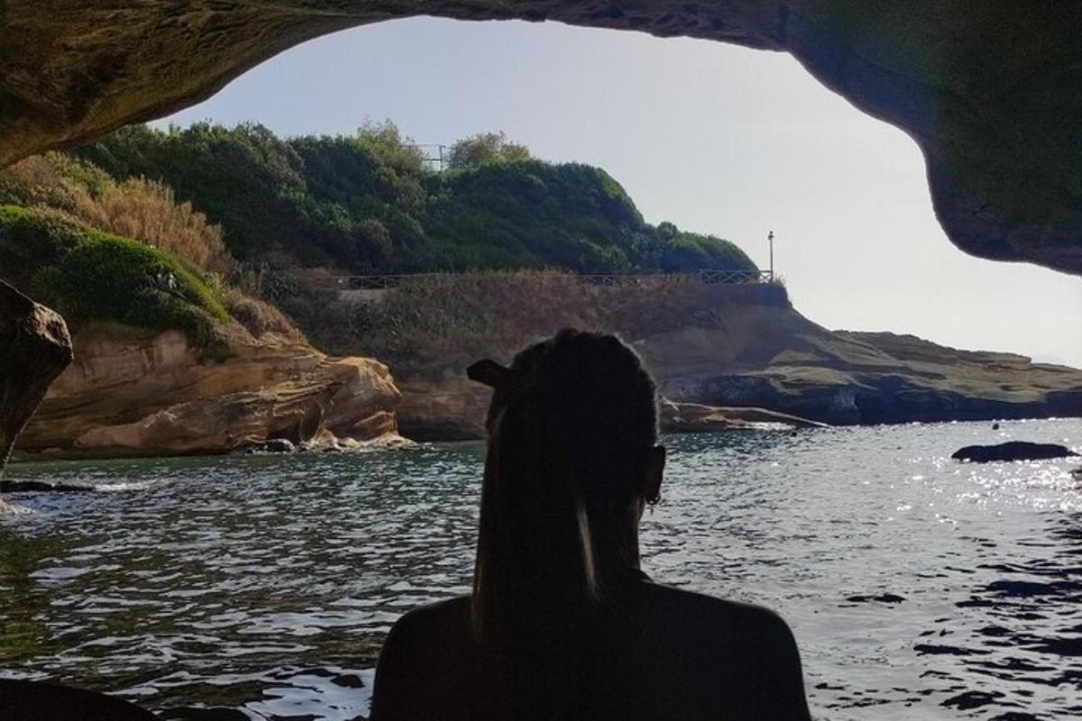 isang babaeng nakaupo sa isang yungib na nakatingin sa tubig