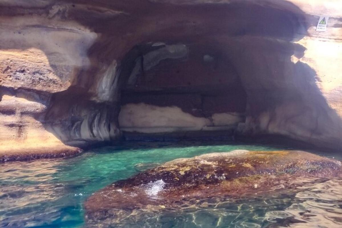 a rock in a pool of water in a cave