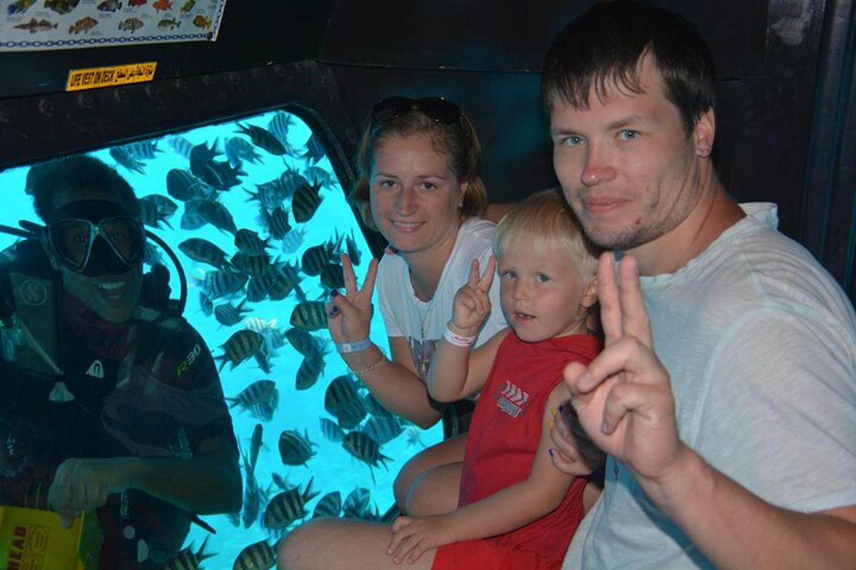 a man and a woman and a child sitting next to a tv