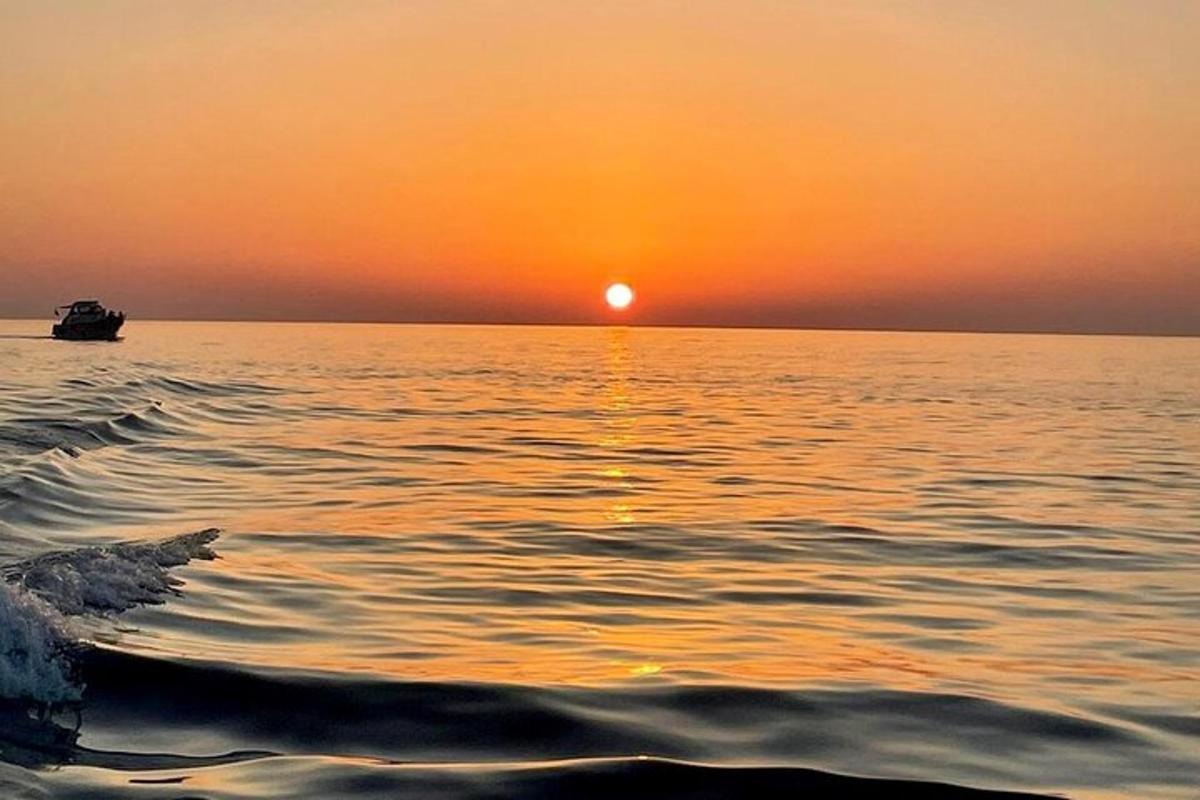 ένα ηλιοβασίλεμα πάνω από ένα υδάτινο σώμα με μια βάρκα