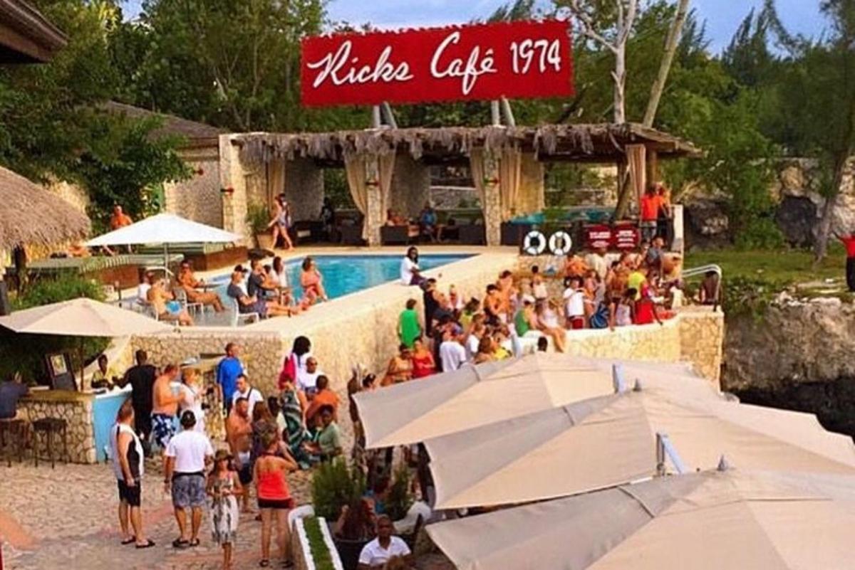 a group of people sitting around a pool at a resort