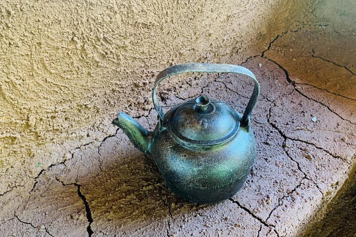 periuk teh hijau duduk di atas tanah