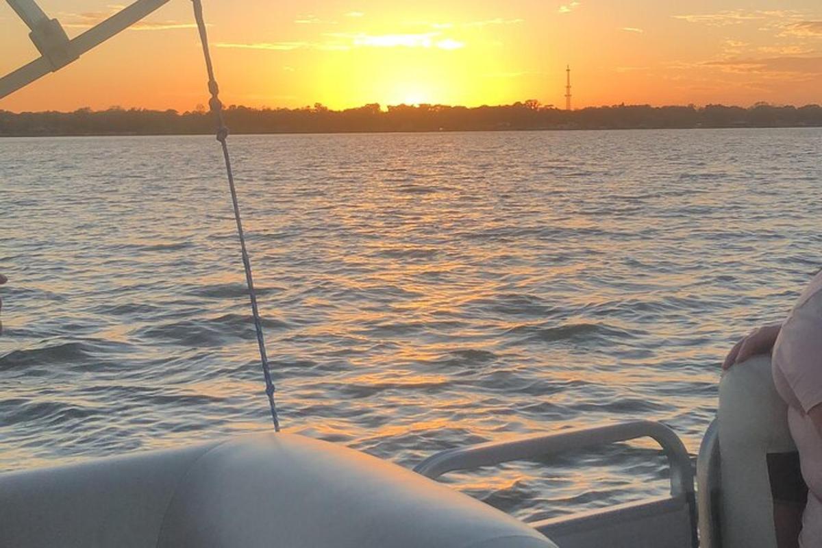 una barca sull'acqua con un tramonto sullo sfondo