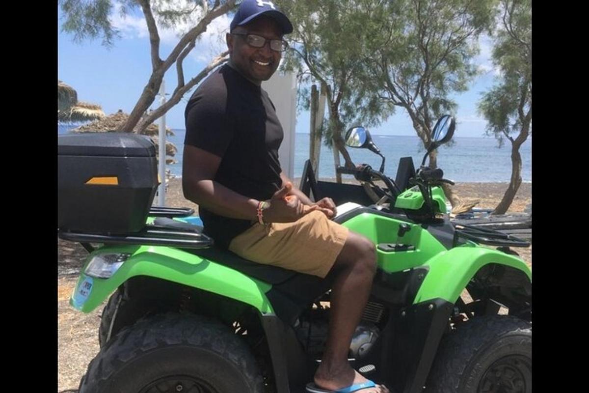 Egy férfi egy zöld ATV-n ül a strandon