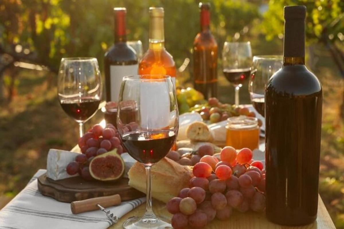 un tavolo con bicchieri di vino, uva e formaggio