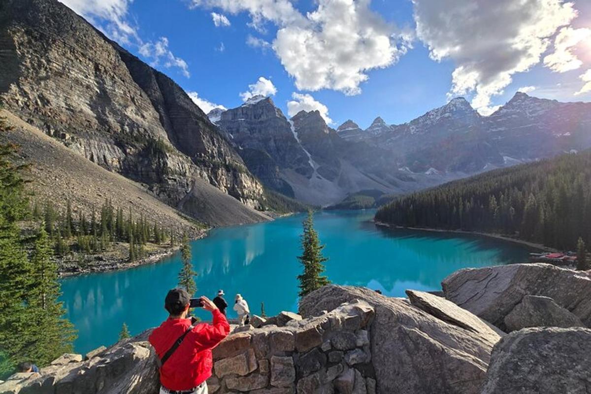 a man taking a picture of a mountain lake