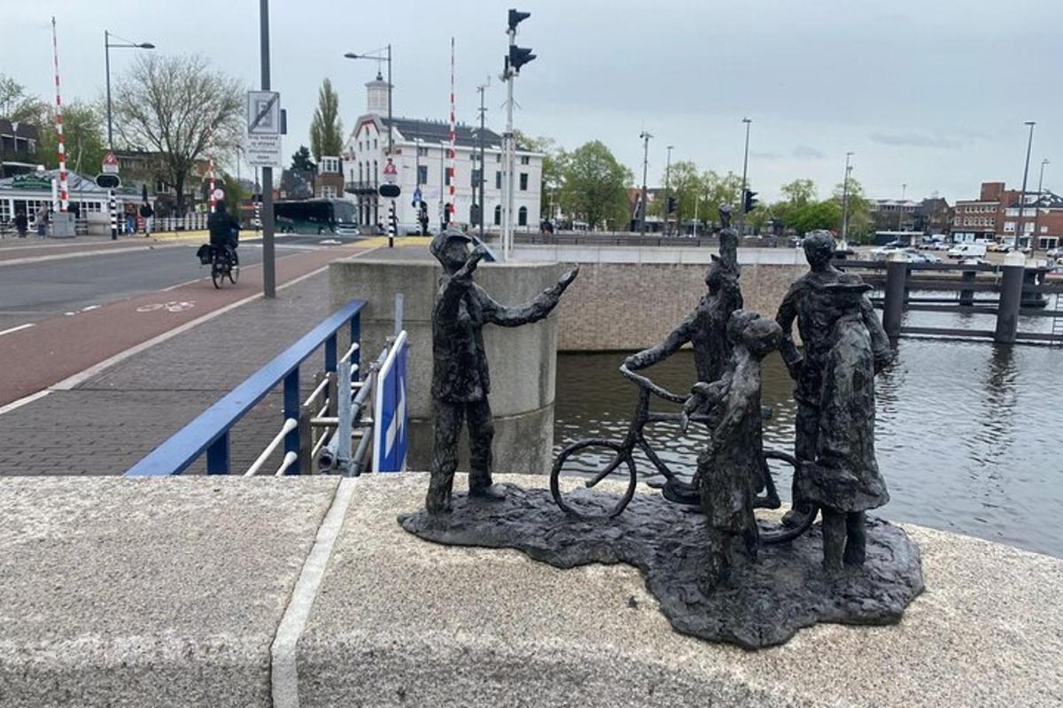 a statue of people on a bridge with a bike