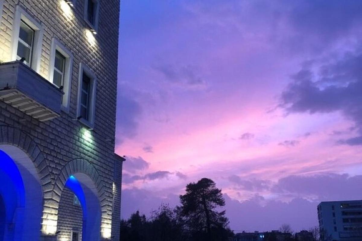 ein Gebäude mit einem Sonnenuntergang am Himmel