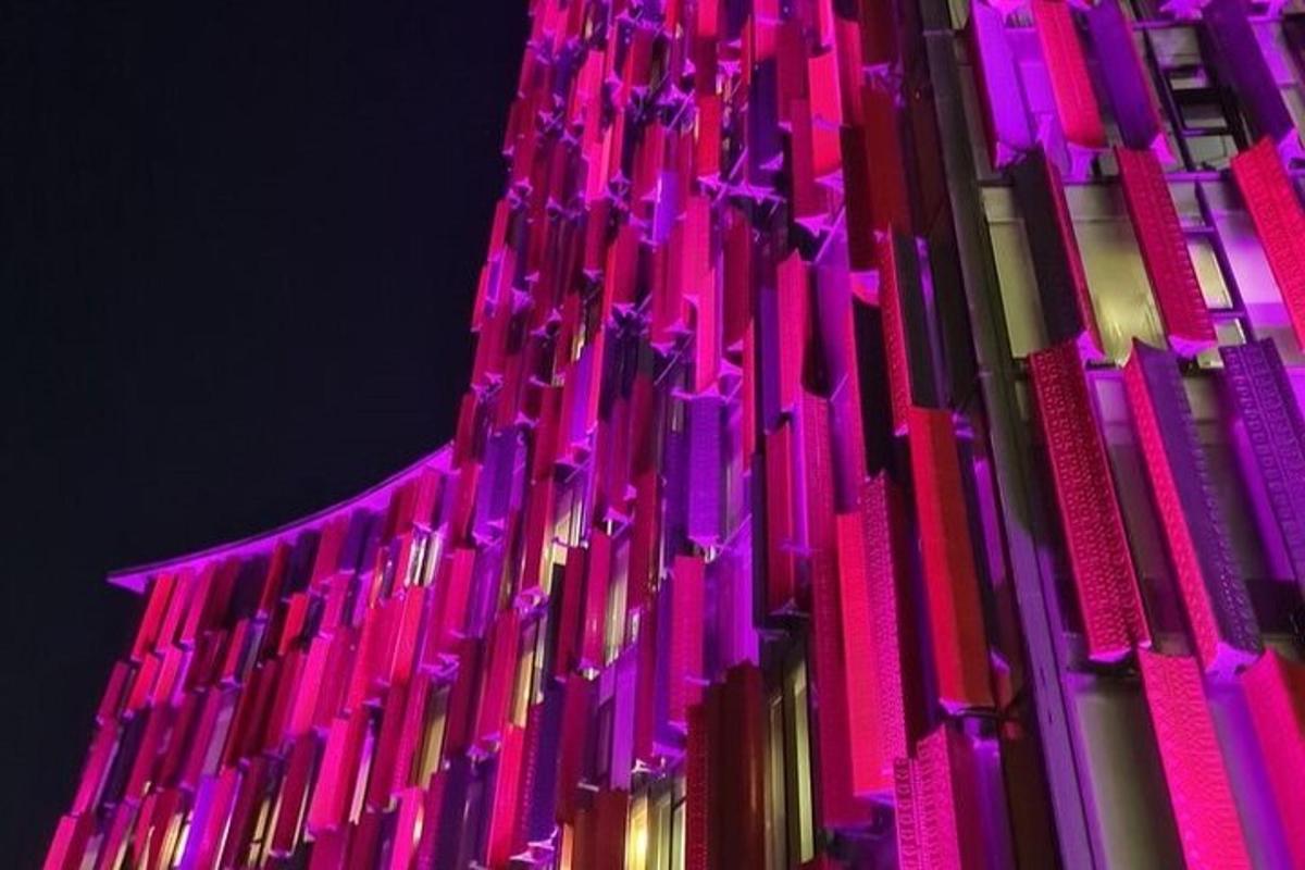 ein Gebäude ist in Pink und Lila beleuchtet