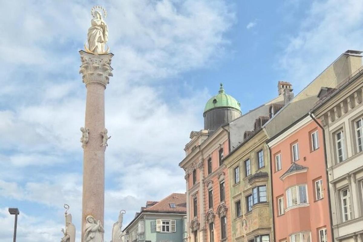una statua in cima a una colonna di fronte agli edifici