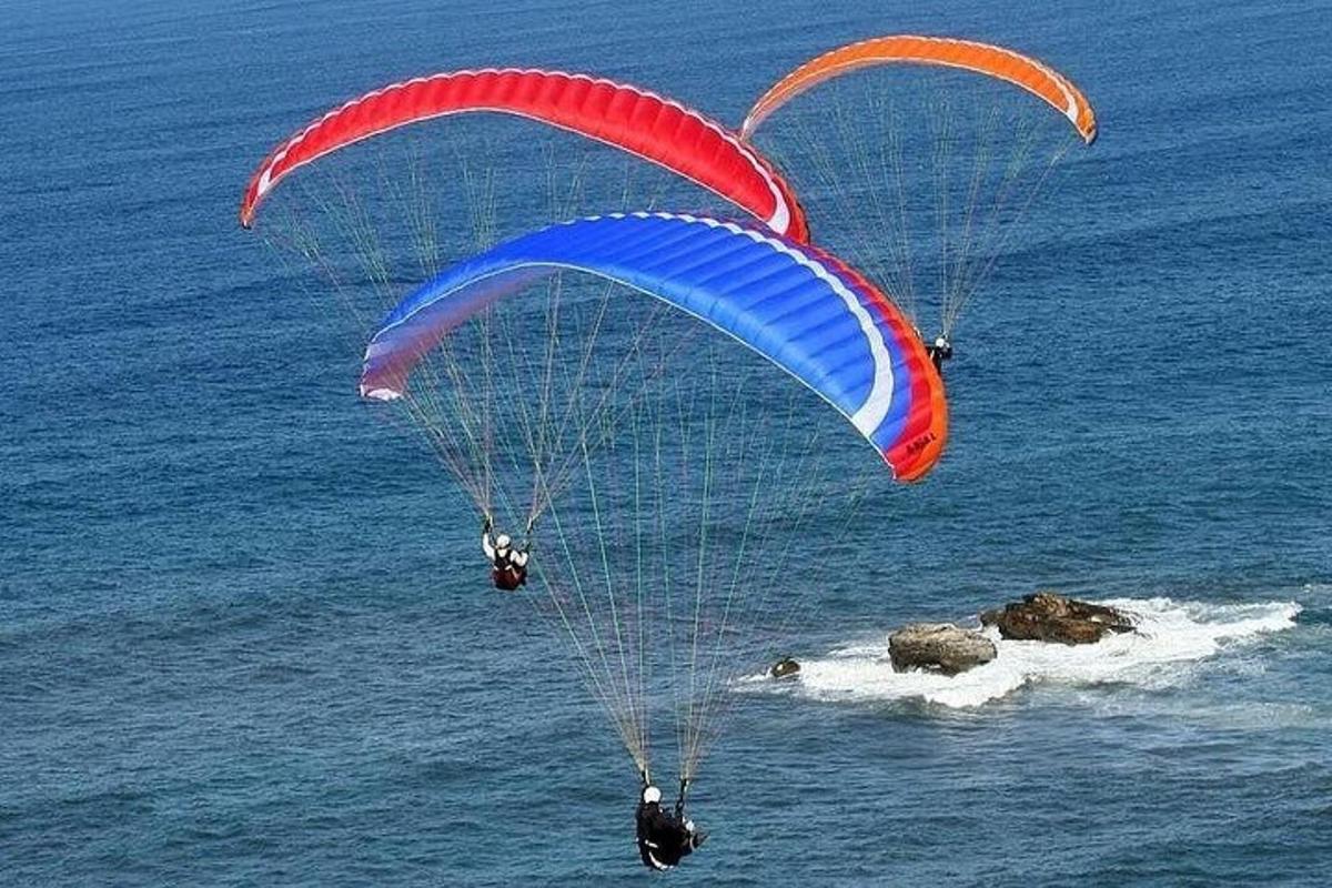 Dos personas en un paracaídas volando sobre el océano