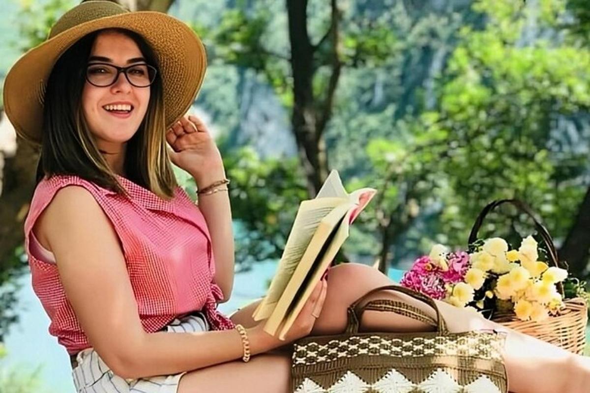 eine Frau, die in einem Korb sitzt und ein Buch liest