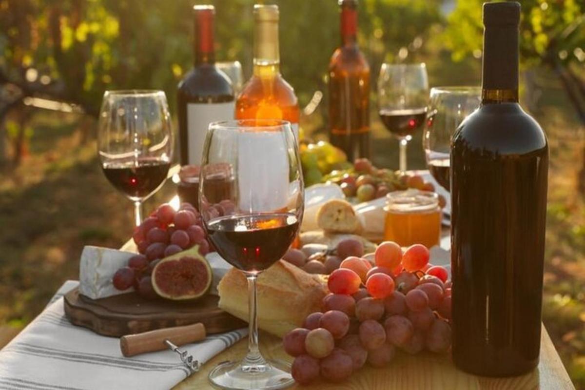 Una mesa con copas de vino y uvas encima.