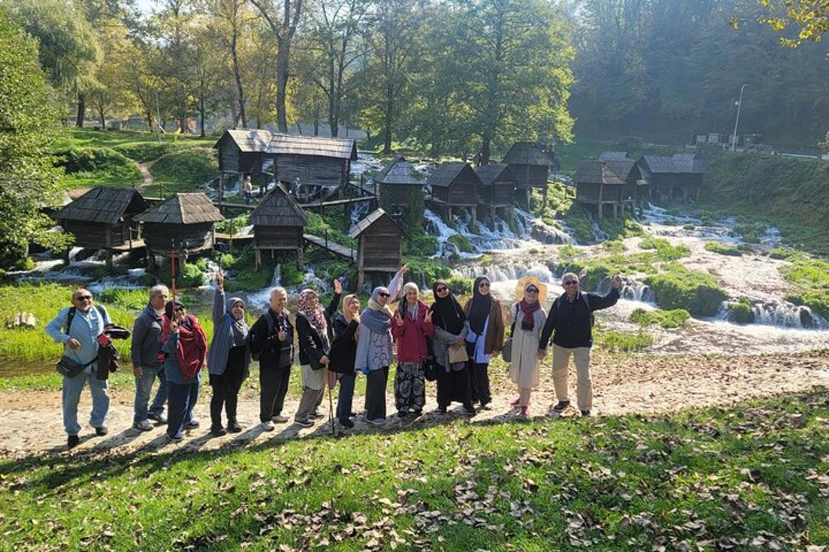 grupa ludzi stojąca przed wodospadem