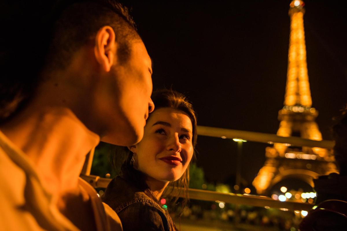 a man and a woman standing in front of the eiffel tower