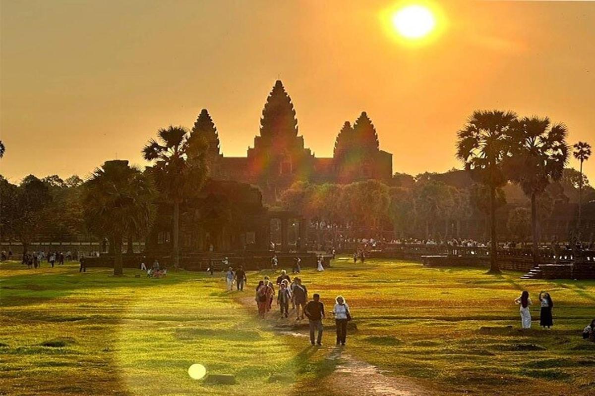 um grupo de pessoas caminhando em um parque ao pôr do sol