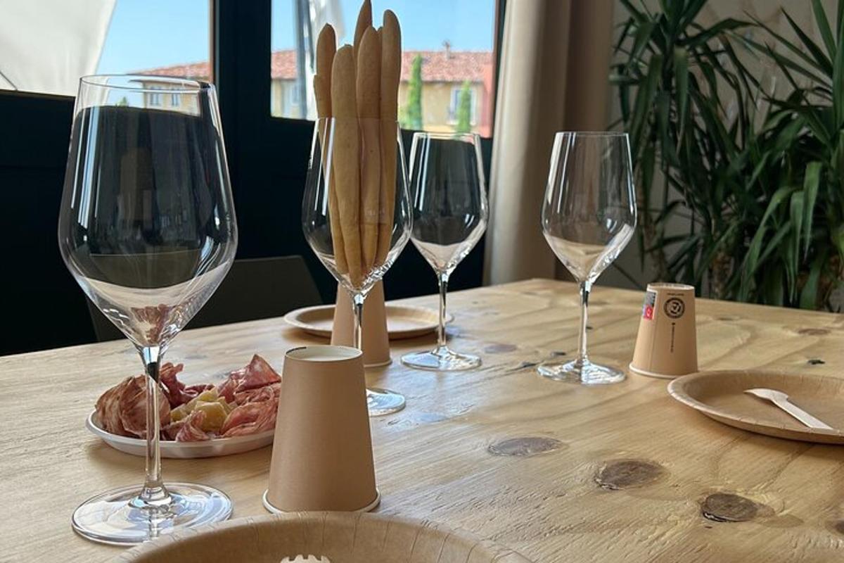 uma mesa de madeira com três taças de vinho e um prato de comida