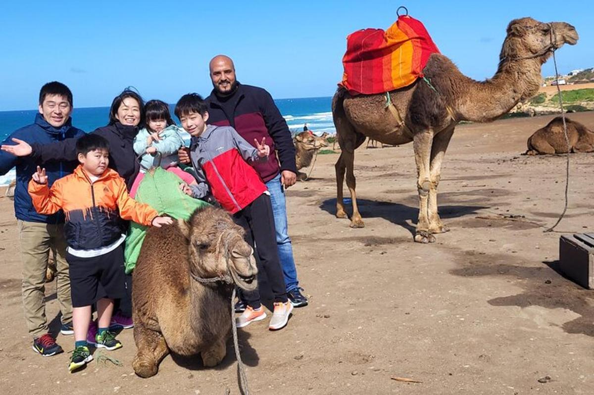 una famiglia in posa con un cammello sulla spiaggia