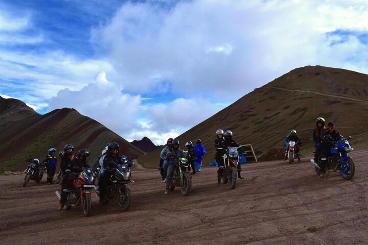 um grupo de pessoas andando de motocicleta em uma estrada de terra