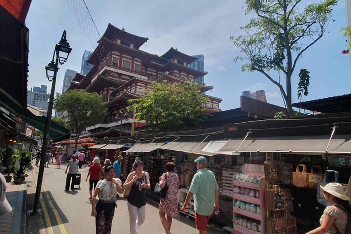 a group of people walking through a market with a building