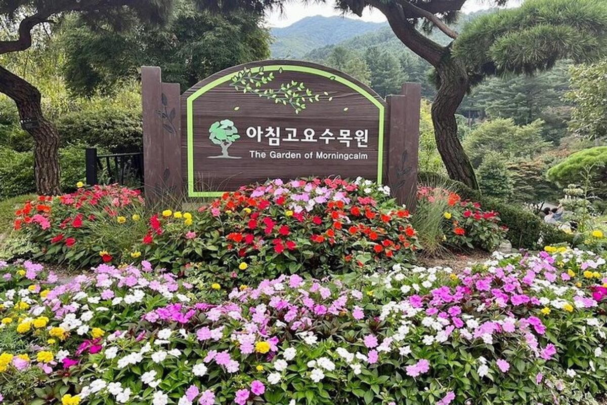 a sign in a garden with flowers