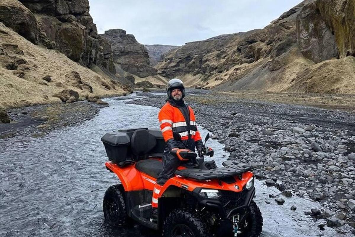 a man riding a four wheeler through a river