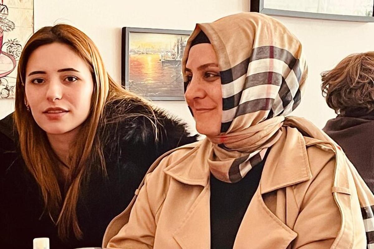 una donna che indossa l'hijab seduta accanto a un'altra donna