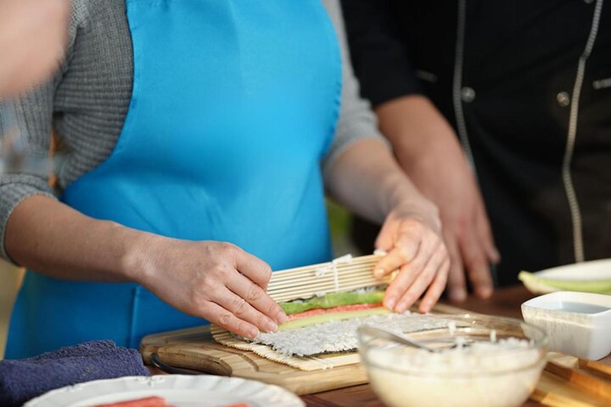 skupina lidí připravujících jídlo na prkénku