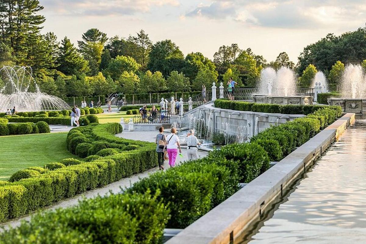 two people walking through a garden with a fountain