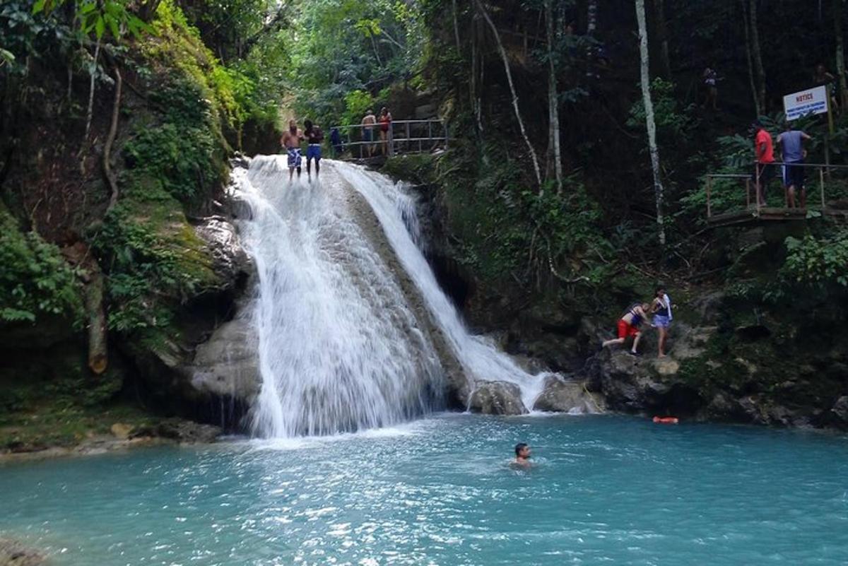 una persona che nuota in una piscina di fronte a una cascata