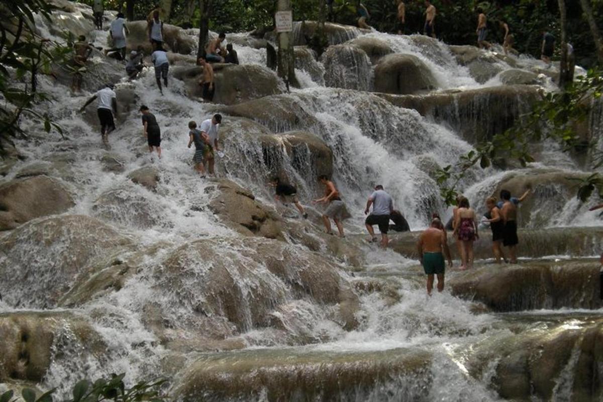 sekumpulan orang berdiri di atas batu di air terjun