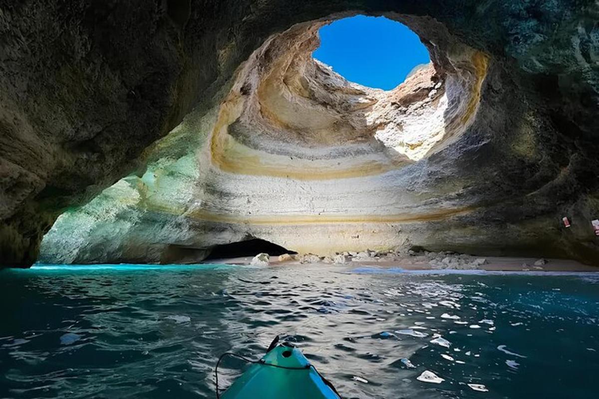un kayakista che rema attraverso una grotta nell'acqua