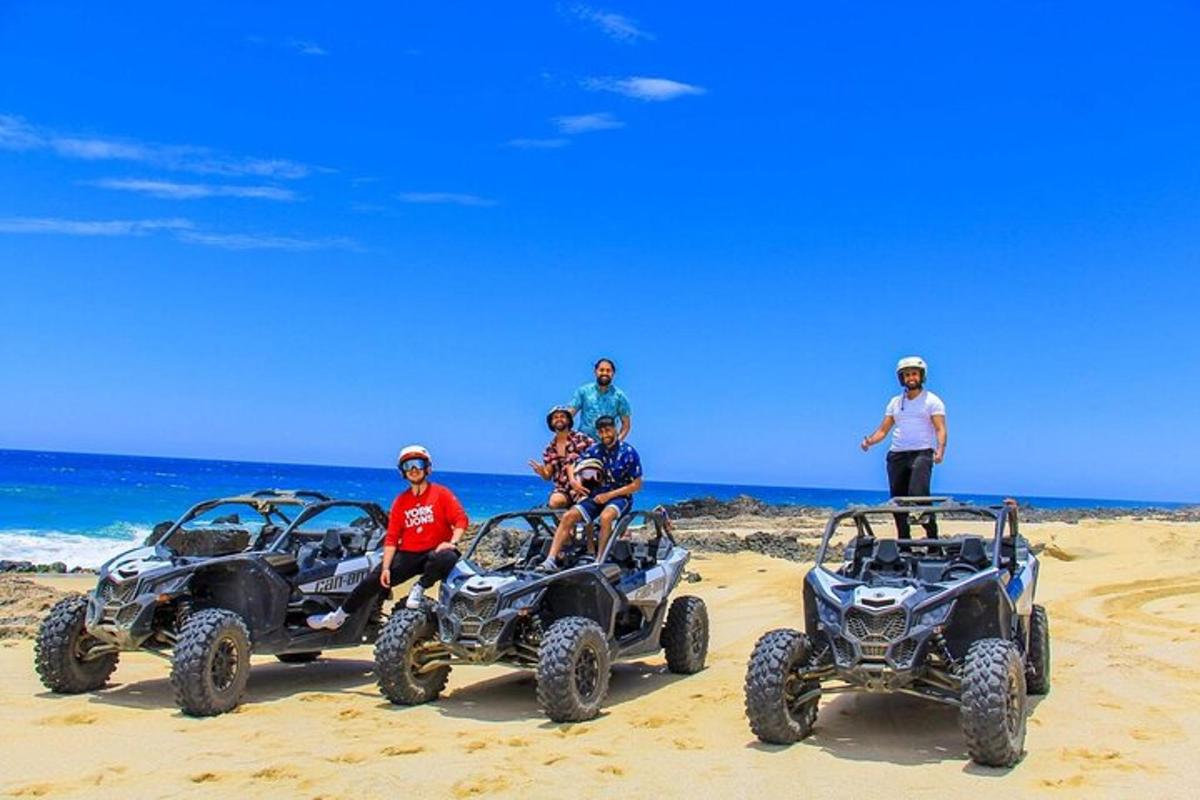 a group of people sitting in atvs on the beach
