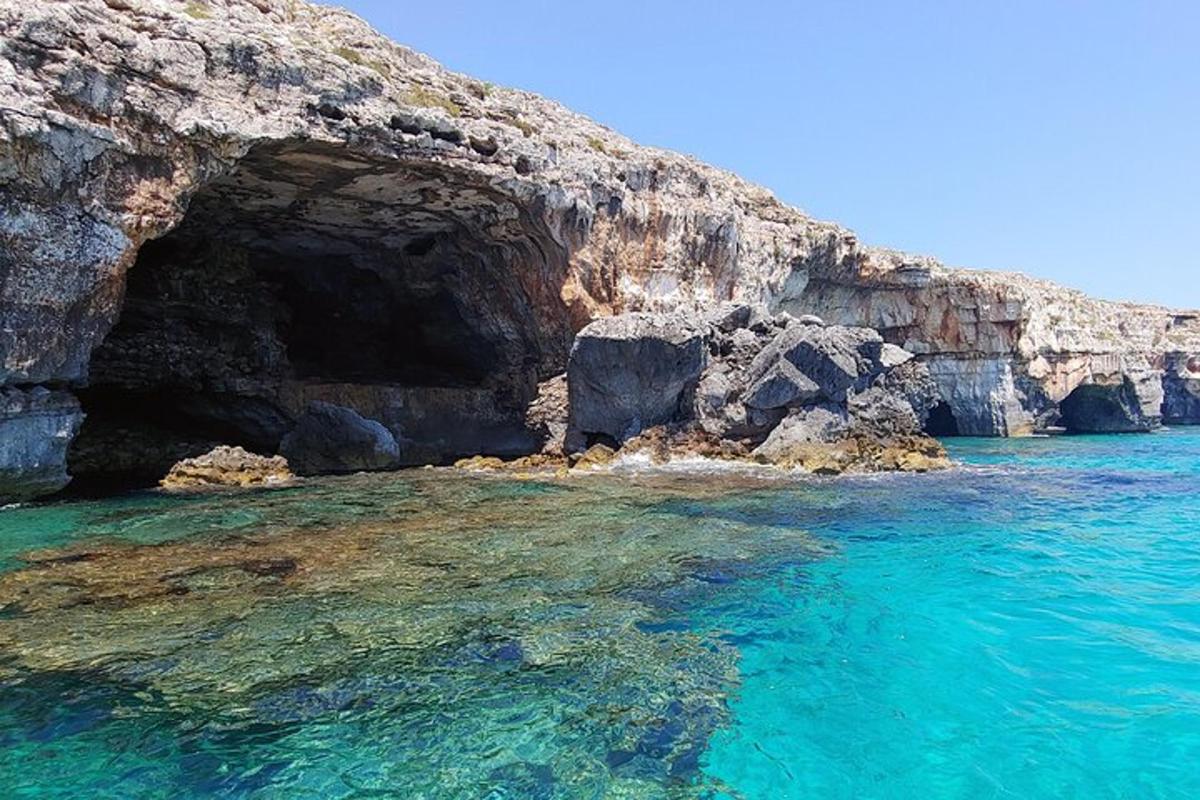 una grotta nell'acqua accanto a una scogliera