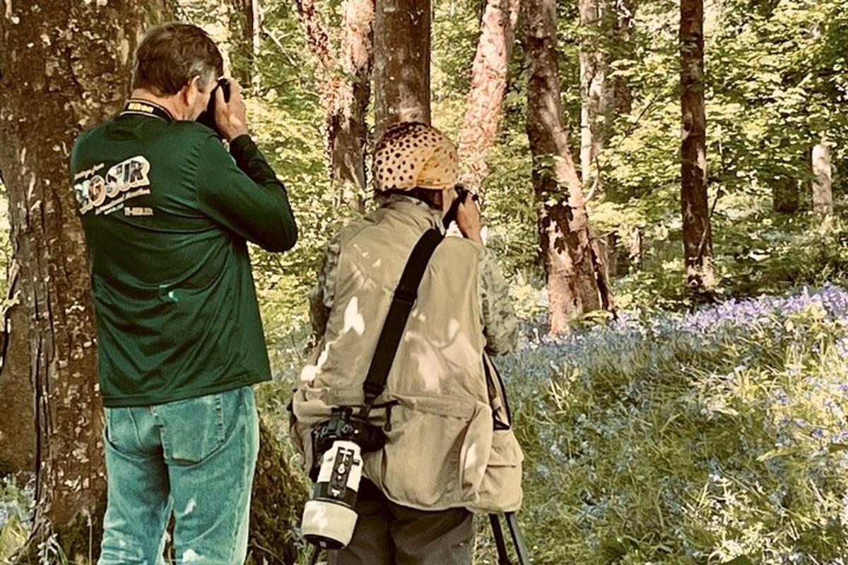 Un hombre y una mujer tomándose fotos en el bosque.